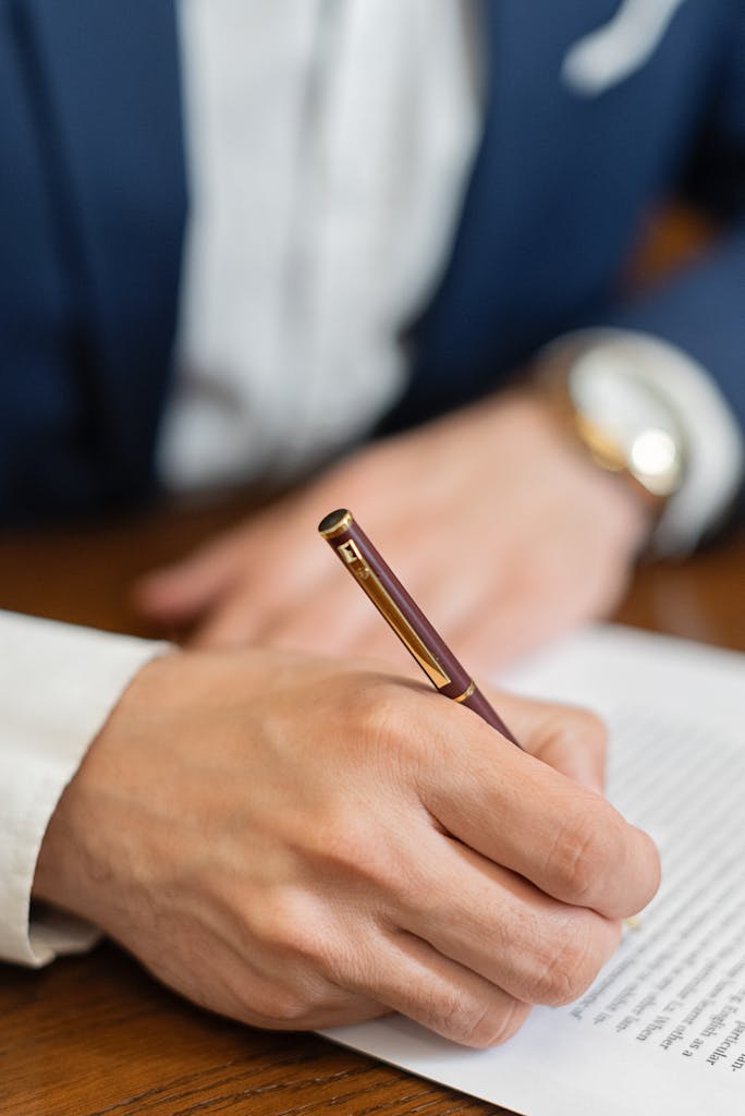A Person Signing a Document in Close-up Shot